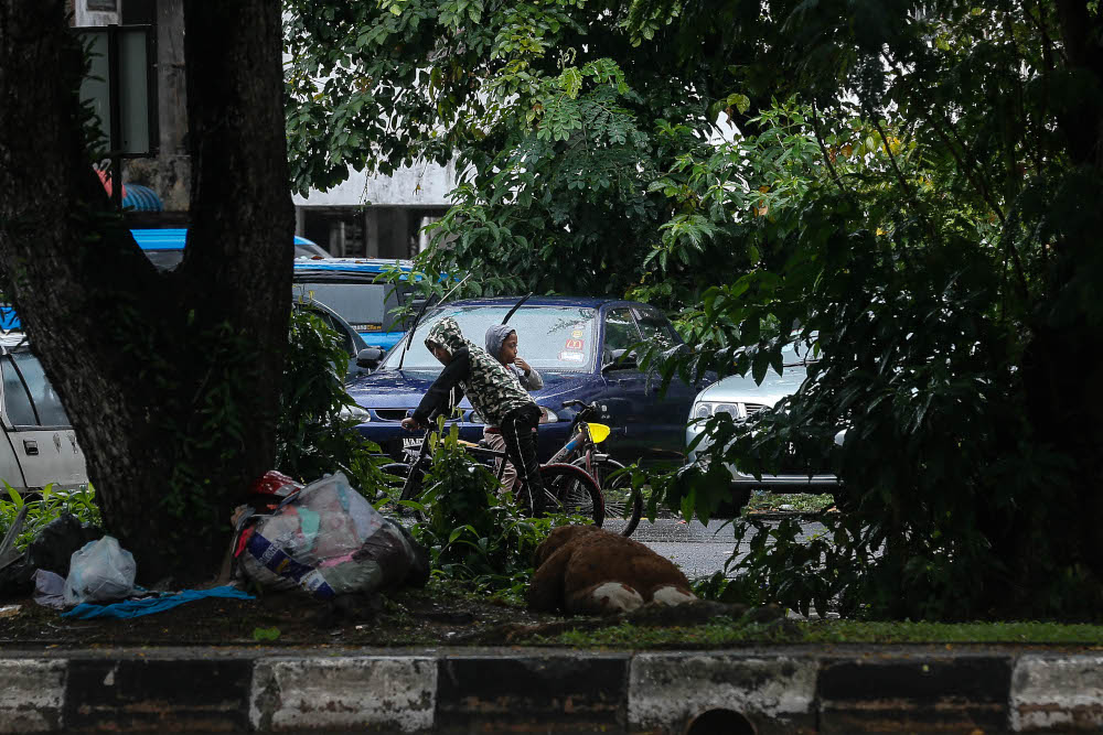 Children wearing raincoats are seen playing under a light drizzle after the area experienced rain since morning due to the monsoon season in Seberang Jaya October 7, 2020. u00e2u20acu201d Picture by Sayuti Zainudin