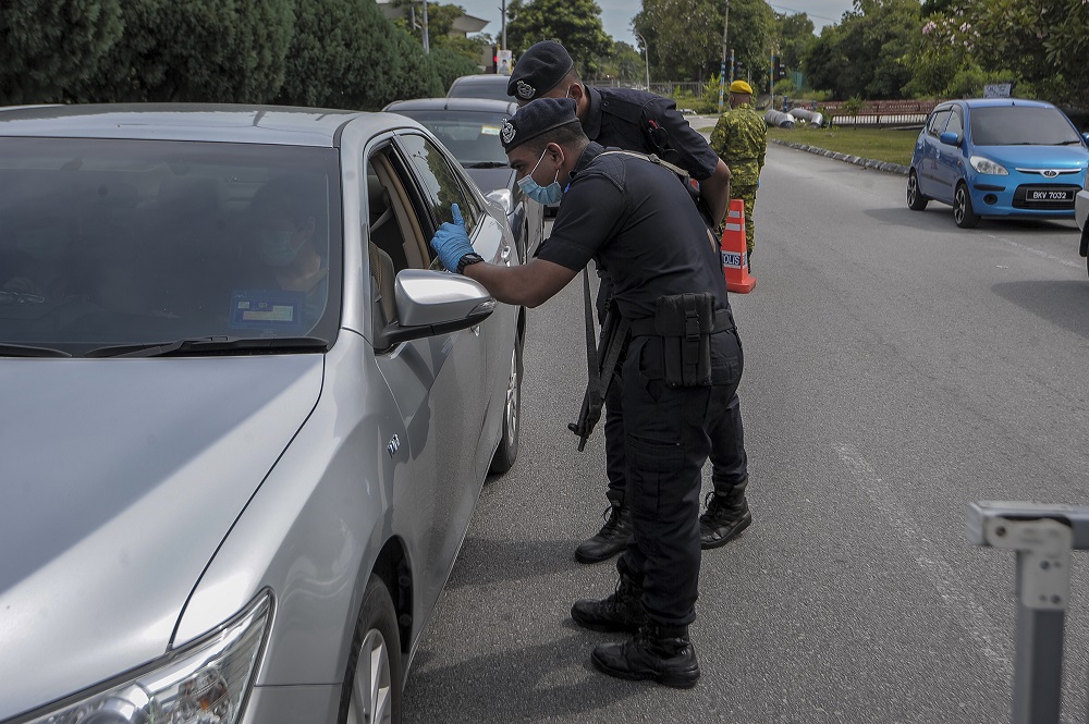 Policemen conduct checks on vehicles at a roadblock at Taman Sri Andalas in Klang October 10, 2020. — Picture by Shafwan Zaidon