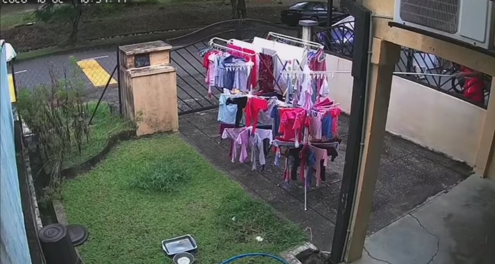 Screenshot from Nur Syazana Izhamu00e2u20acu2122s CCTV recording showing her neighbour removing her clothes hanger stands from the sun to the porch area. u00e2u20acu201d Source from Facebook/ Nur Syazana Izham