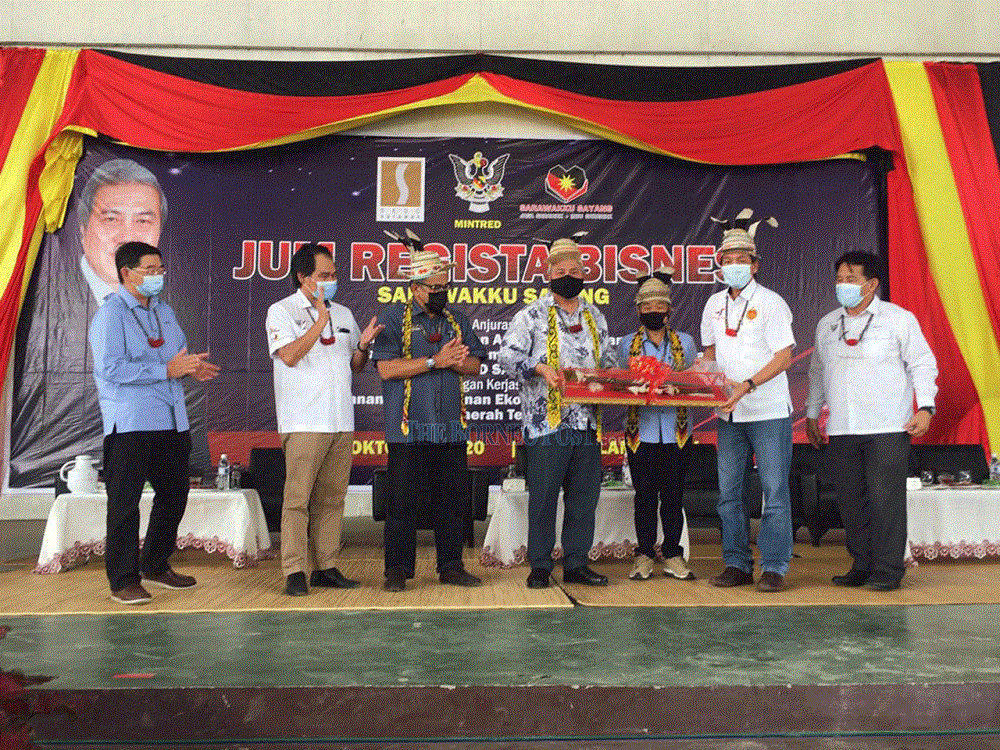 Dennis (second right) presents a memento to Awang Tengah. Also seen on stage are (from left) Liaw, Anyi, Hasbi, Naroden and Baru. u00e2u20acu201d Borneo Post Online pic