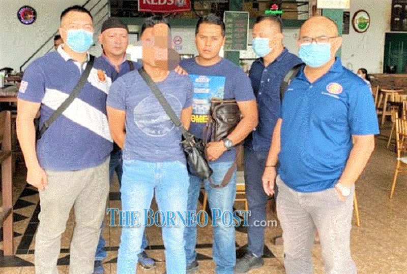 One of the suspects (third left) detained to facilitate investigation. u00e2u20acu201d Borneo Post Online pic