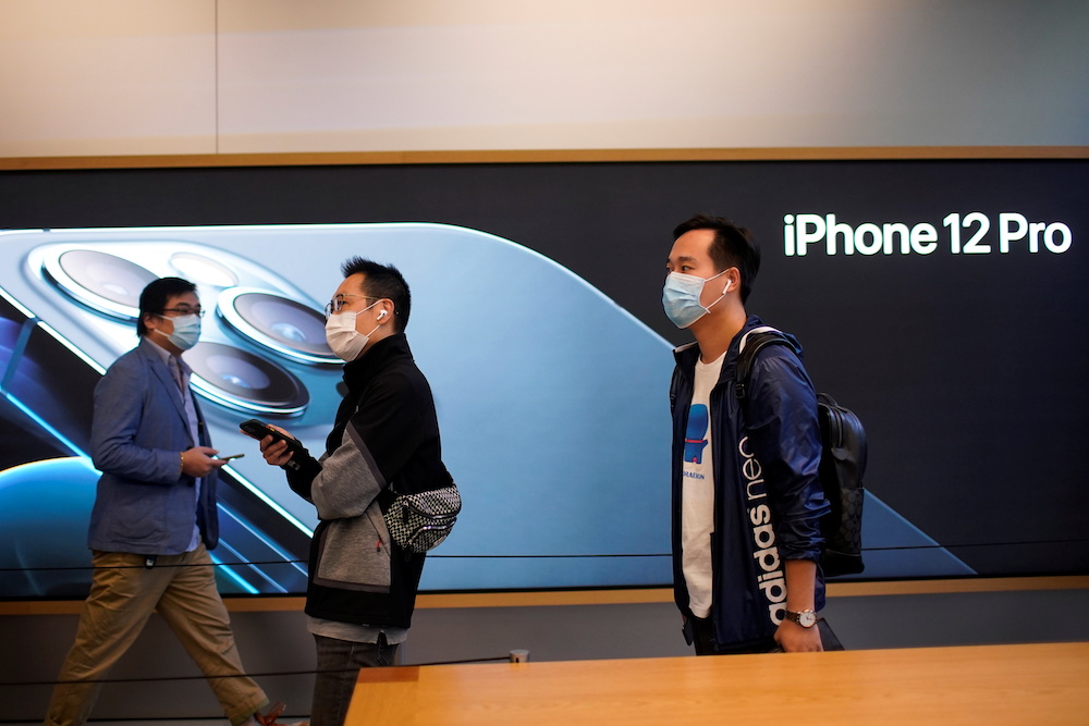 People wearing face masks wait at an Apple Store before Apple's 5G new iPhone 12 go on sale in Shanghai China October 23, 2020. u00e2u20acu201d Reuters pic