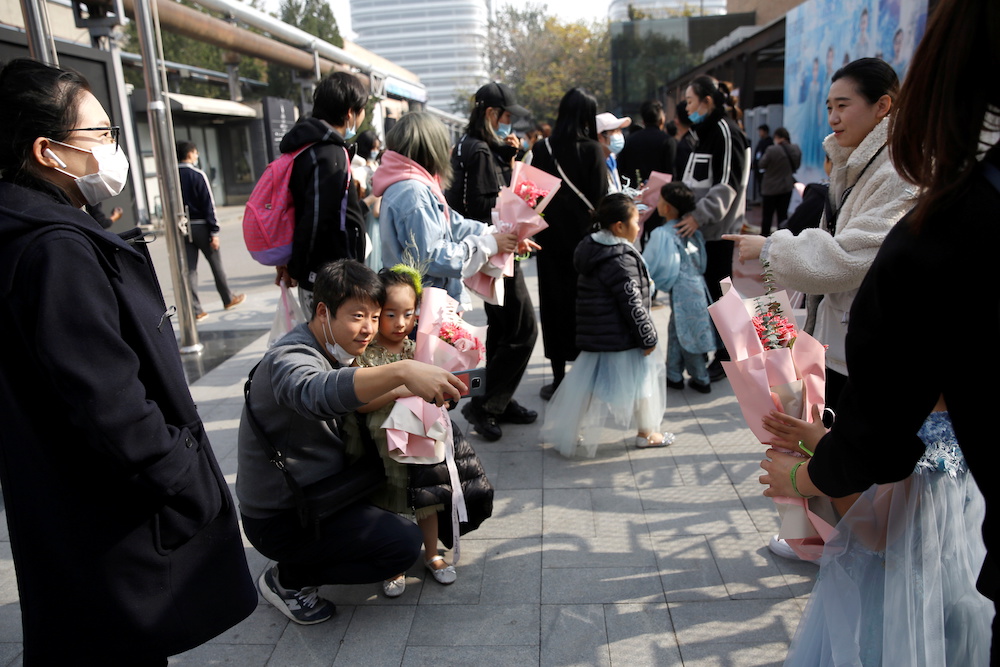 A man takes selfies with a child model outside a venue for China Fashion Week, in Beijing, China October 26, 2020. u00e2u20acu201d Reuters pic