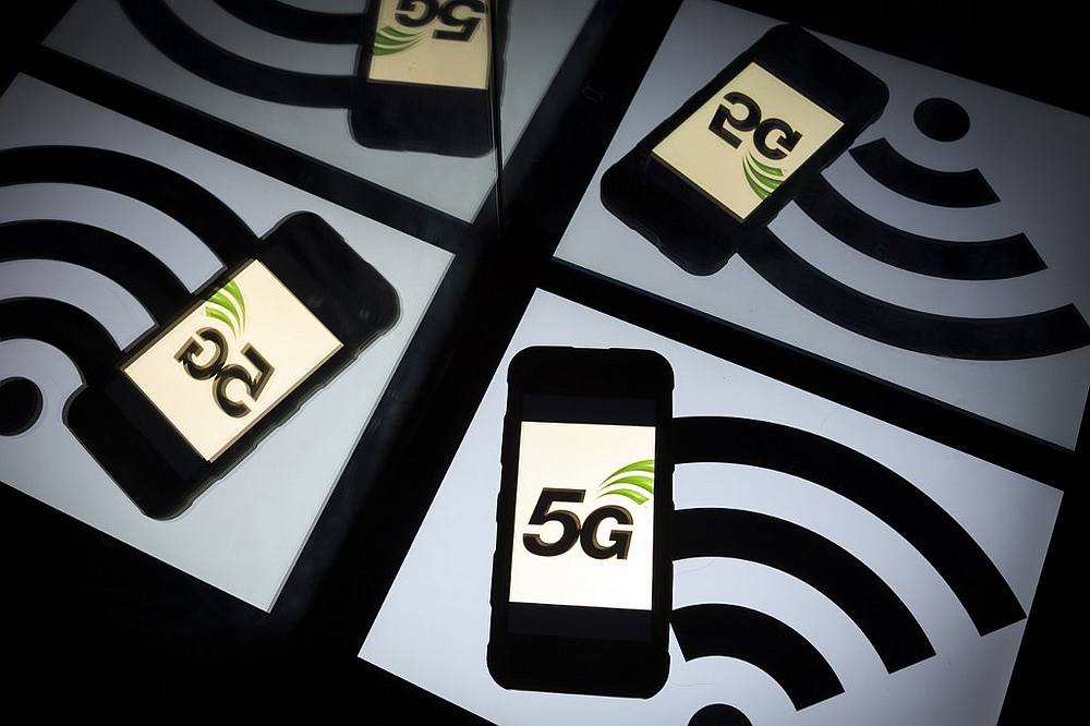 This picture shows the 5G wireless technology logo displayed on a smartphone and a wireless signal sign on show by a tablet in Paris February 16, 2019. u00e2u20acu201d AFP pic