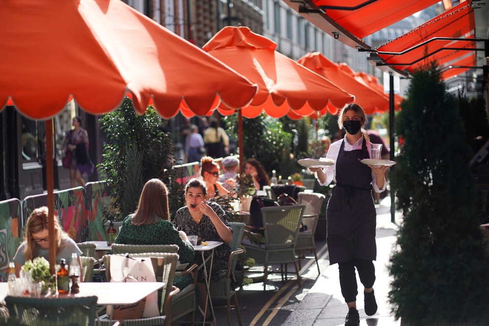 People sit at tables outside restaurants in Soho, amid the coronavirus disease outbreak, in London, Britain, September 20, 2020. u00e2u20acu201d Reuters