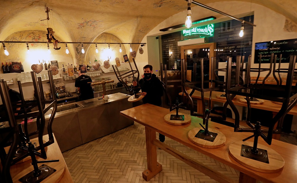 A waiter closes up a pub, as the Czech government mandated restaurants and pubs to shut by 8.00pm to contain the spread of Covid-19 in Prague October 9, 2020. u00e2u20acu2022 Reuters pic