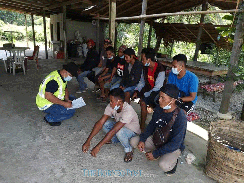 A GOF personnel records the details of the nine foreigners. u00e2u20acu201d Borneo Post Online pic