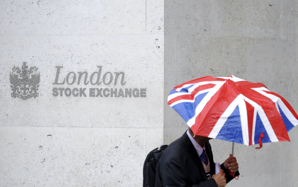 File photo of a worker sheltering from the rain as he passes the London Stock Exchange in the City of London at lunchtime October 1, 2008. u00e2u20acu2022 Reuters picnnn