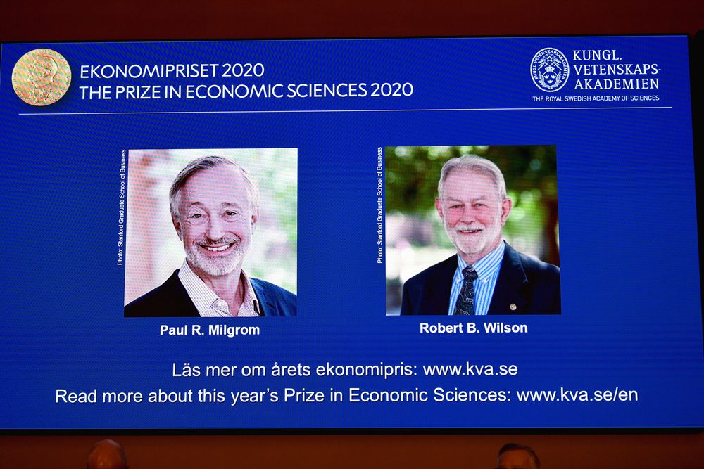 Pictures of the winners of the 2020 Nobel prize in economic sciences, Paul R. Milgrom and Robert B. Wilson, are displayed on a screen at a news conference in Stockholm, Sweden October 12, 2020. u00e2u20acu201d TT News Agency/Anders Wiklund pic via Reuters