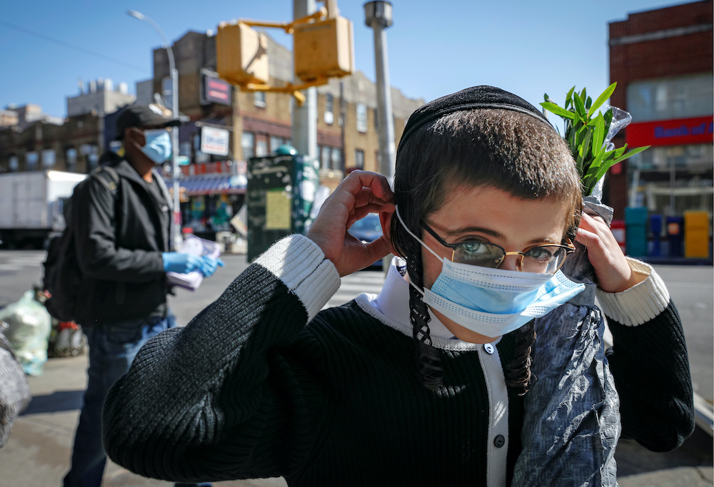 A young Ultra-Orthodox Jewish boy puts on a mask, during the outbreak of coronavirus disease in the Borough Park section of Brooklyn, New York, US, October 9, 2020. u00e2u20acu2022 Reuters picnn