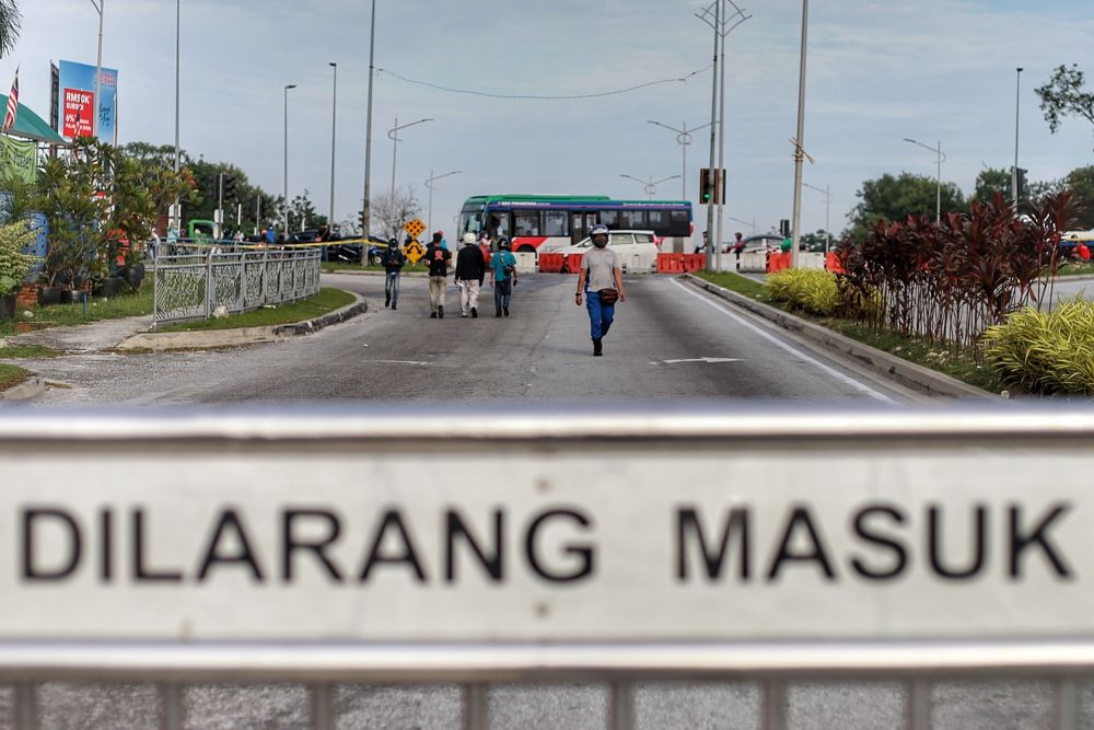 Members of the public opt to walk to their places of work after the police blocked the entrance to Persiaran Sungai Buloh as the conditional control movement order kicks in on October 14 2020. u00e2u20acu201d Picture by Ahmad Zamzahuri