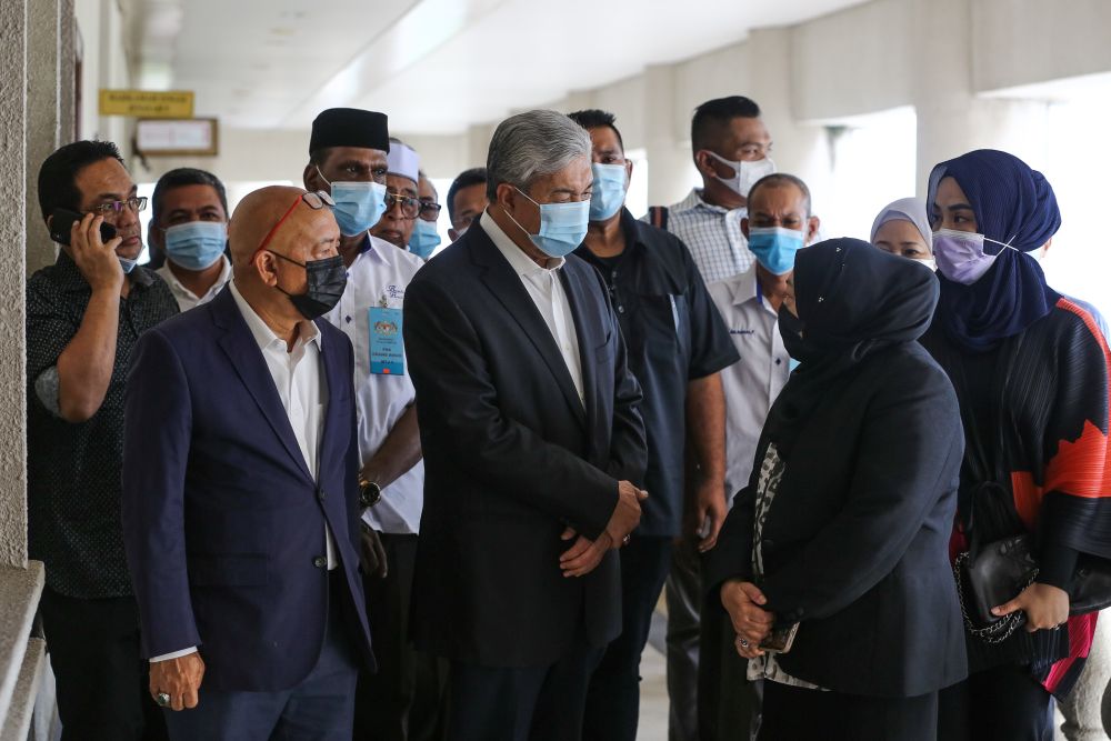 Datuk Seri Ahmad Zahid Hamidi (left) talk to former Malaysian External Intelligence Organisation chief Datuk Hasanah Abdul Hamid at the Kuala Lumpur High Court October 12, 2020. u00e2u20acu201d Picture by Yusof Mat Isa 