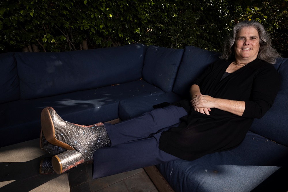 Andrea Ghez, Professor of Astrophysics at the University of California Los Angeles wears a pair of boots with the galaxy on them as she poses for a portrait in her backyard after being awarded the 2020 Nobel Prize in physics in Los Angeles October, 6, 202
