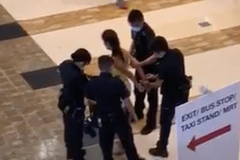 Singapore police officers placing handcuffs on a 35-year-old woman before she is led away. u00e2u20acu201d LinkedIn screengrab via TODAY