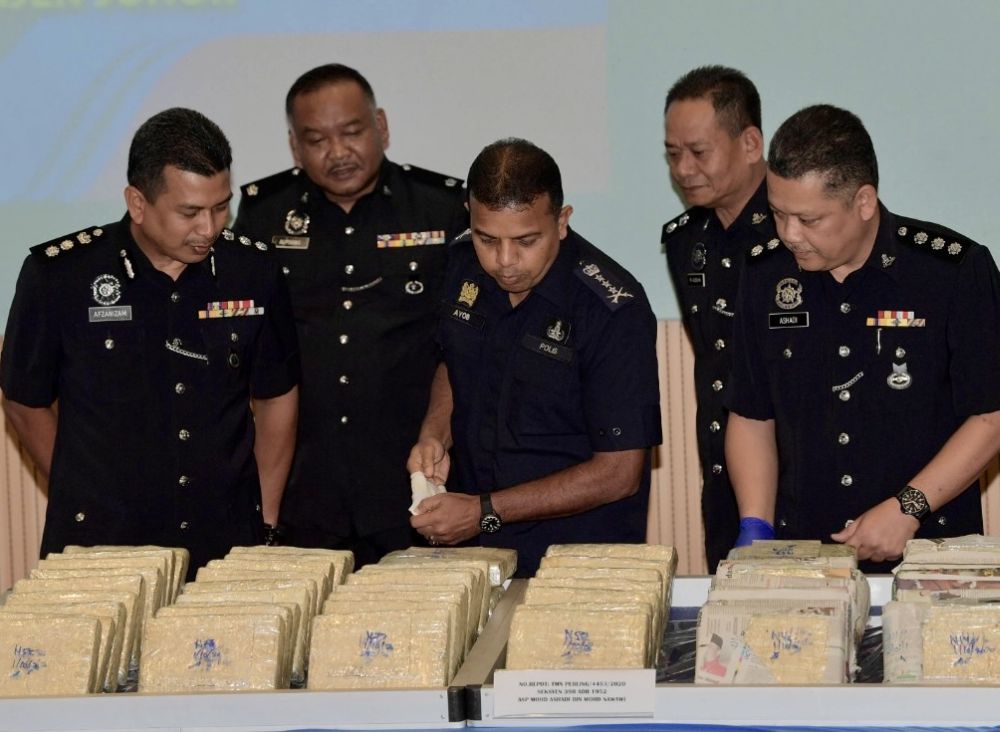 Johor police chief Datuk Ayob Khan Mydin Pitchay (centre) looking at seized drugs on display at the Johor police contingent headquarters in Johor Baru today. u00e2u20acu201d Picture by Ben Tann
