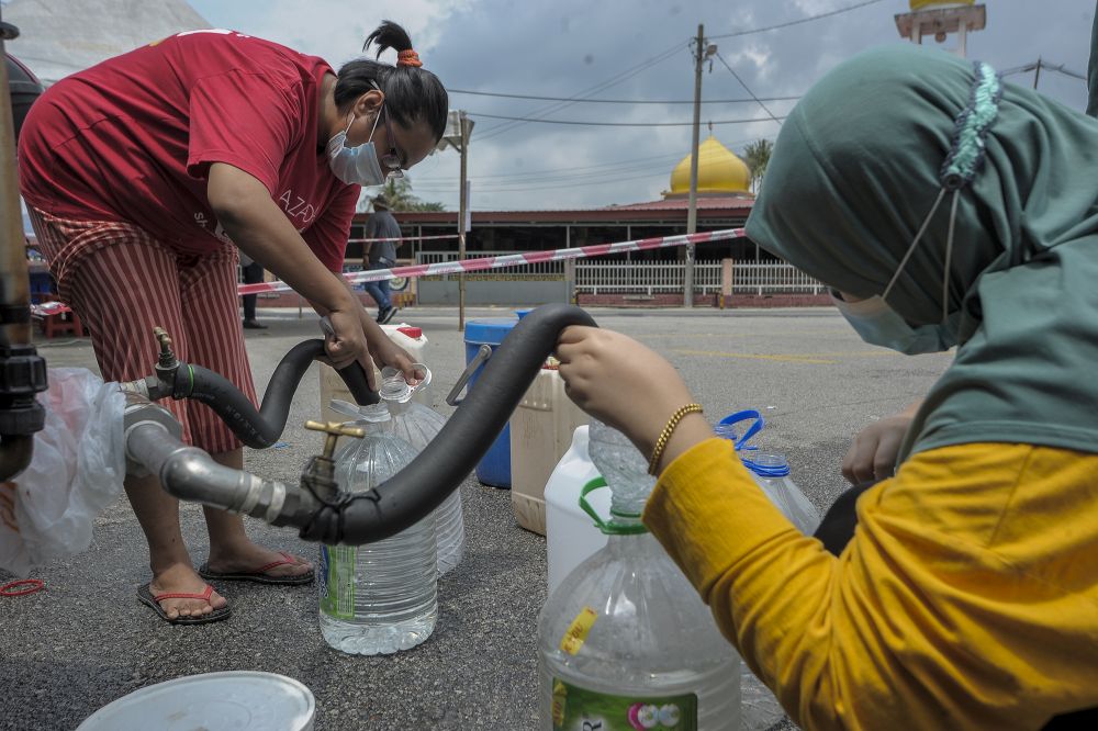 Residents fill their pails at a water point in Bangi following the water disruption in Hulu Selangor October 6, 2020. u00e2u20acu2022 Picture by Shafwan Zaidon