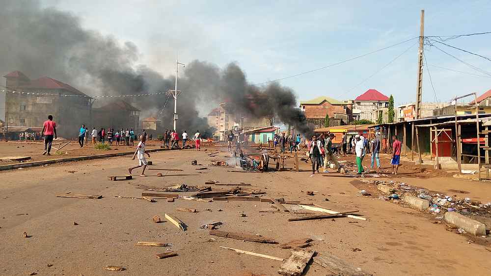Smoke rises and wood litters the road as opposition supporters set up barricades to protest against preliminary presidential election results in Ratoma district of Conakry, Guinea October 21, 2020. u00e2u20acu201d Reuters pic