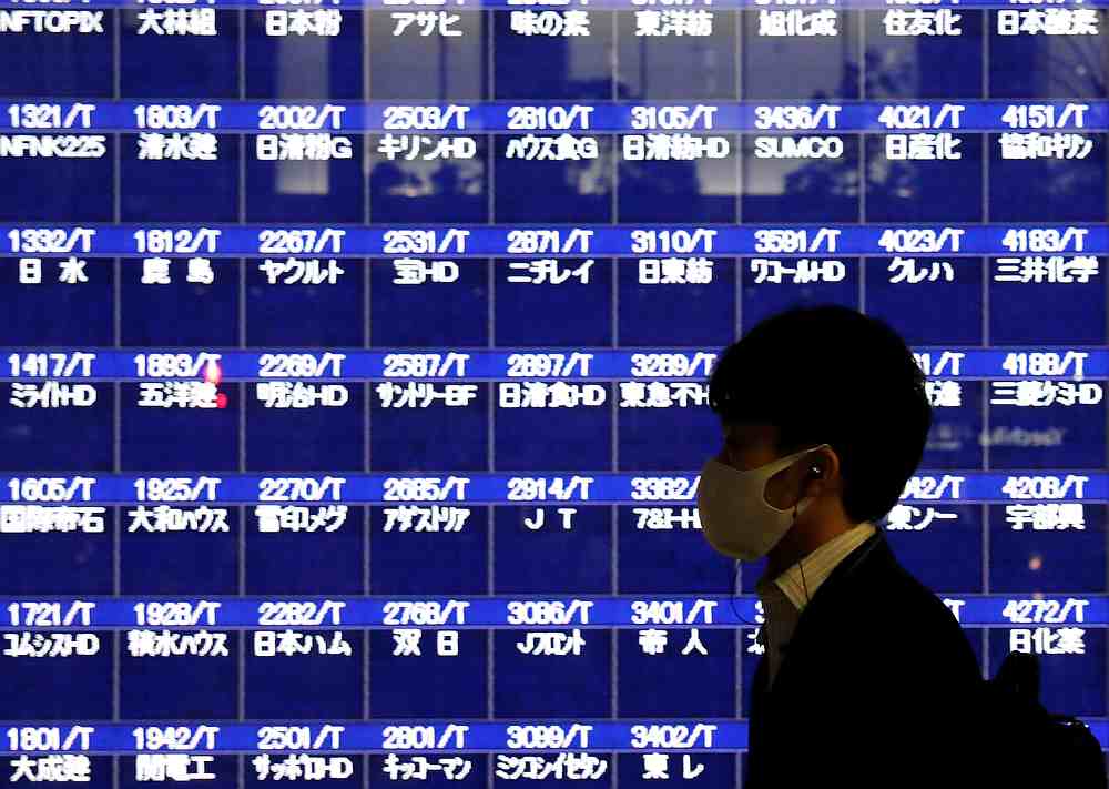 A passerby wearing a protective mask is silhouetted in front of a screen of blank prices after Tokyo Stock Exchange temporarily suspended all trading in Tokyo, Japan October 1, 2020. u00e2u20acu201d Reuters pic