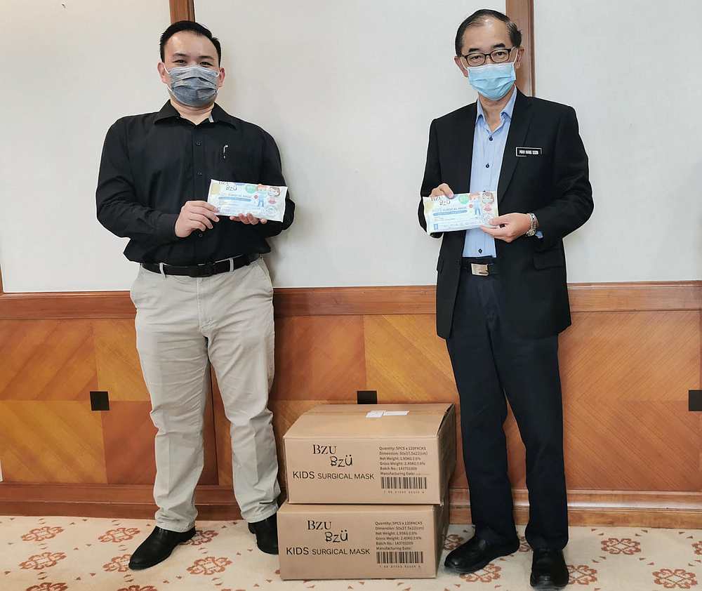 BZU BZU's regional sales director Edmund Chin (left) and deputy Education Minister Datuk Mah Hang Soon (right) with the face masks for students. u00e2u20acu201d Picture courtesy of BZUBZU Malaysia