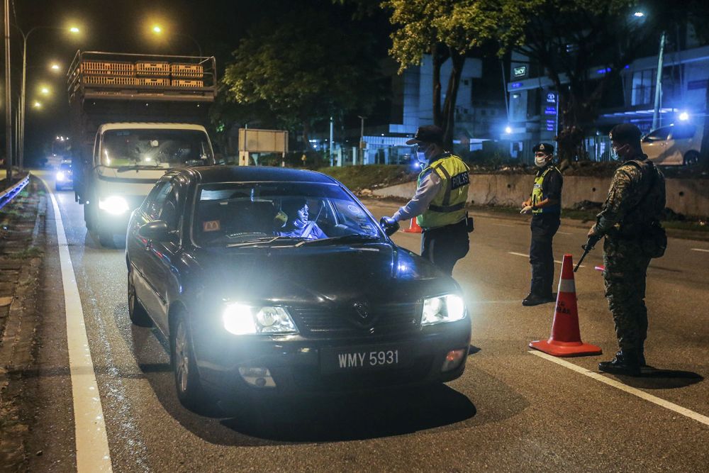 Police and Armed Forces personnel inspect a vehicle at a roadblock on Jalan Ipoh as the conditional movement control order was reintroduced at the stroke of midnight on October 14, 2020. u00e2u20acu201d Picture by Hari Anggara