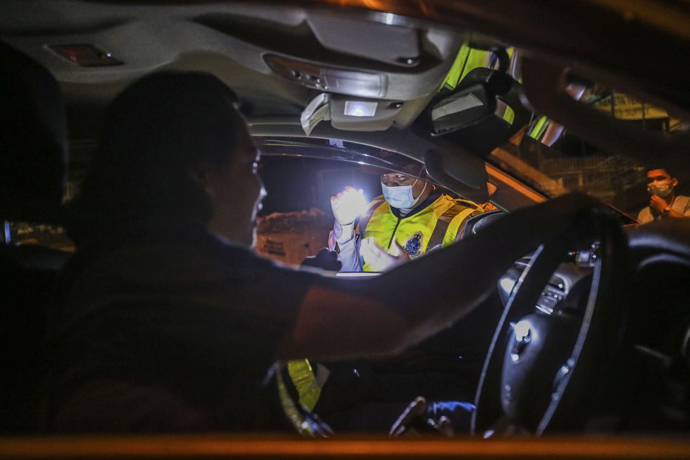 Police and Armed Forces personnel inspect a vehicle at a roadblock on Jalan Ipoh as the conditional movement control order was reintroduced at the stroke of midnight on October 14, 2020. u00e2u20acu201d Picture by Hari Anggara