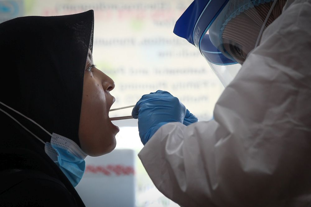 Healthcare workers collect swab samples to test for Covid-19 at the Selcare Clinic in Shah Alam October 4, 2020. u00e2u20acu201d Picture by Hari Anggara