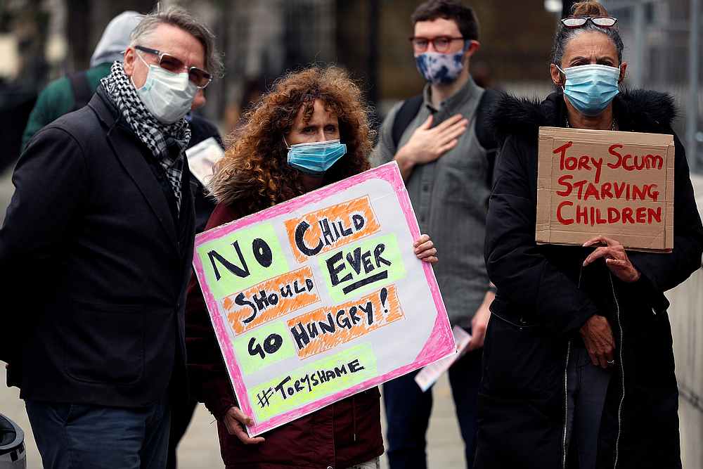 People hold banners during a protest demanding free school meals for children in England, in London, Britain October 24, 2020. u00e2u20acu201d Reuters pic