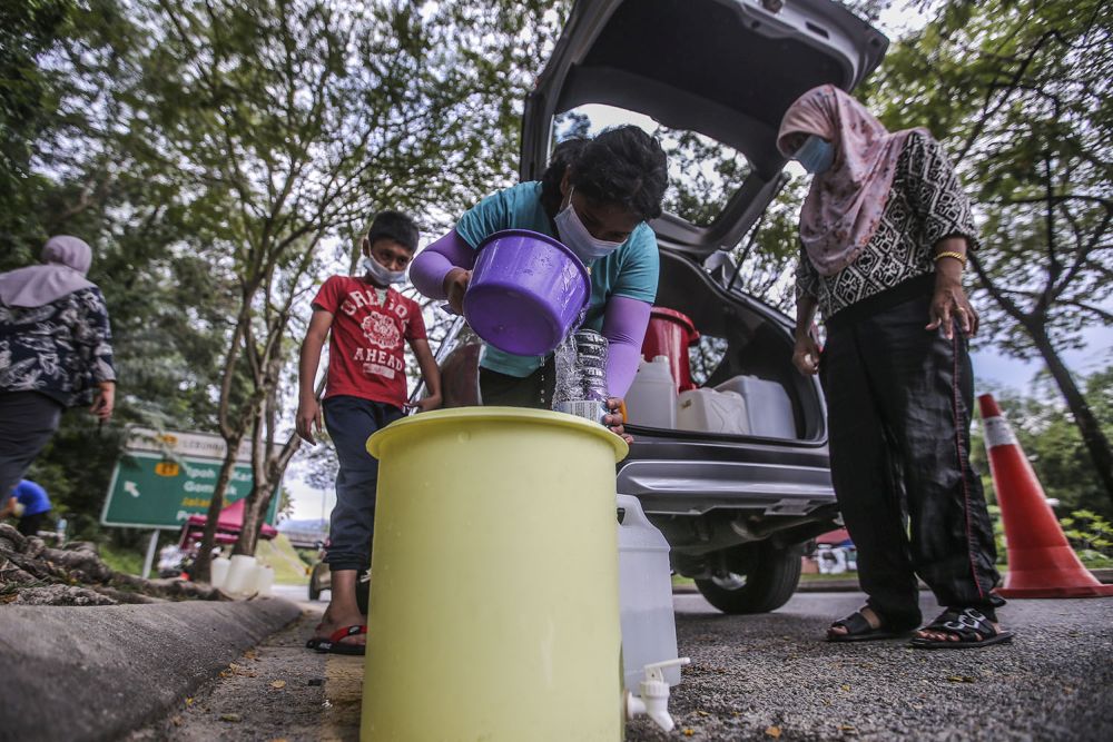 Residents fill their pails at a water point in Keramat AU2 following the latest water disruption October 20, 2020. u00e2u20acu201d Picture by Hari Anggara