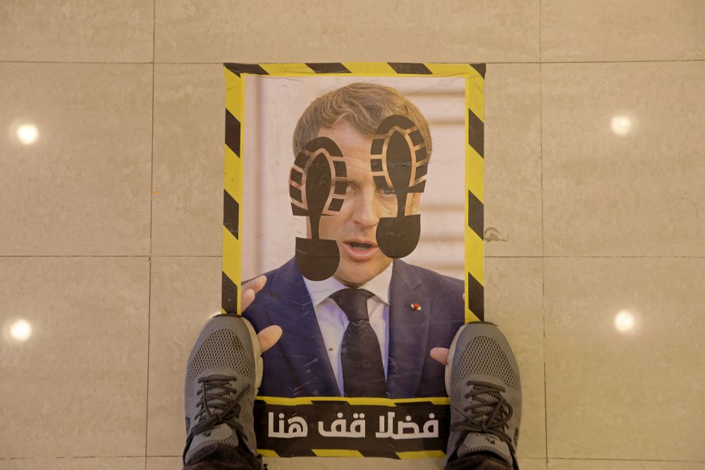 A man stands at a social distancing floor sticker printed with the photo of French President Emmanuel Macron in a store in Tripoli, Libya October 27, 2020. u00e2u20acu201d Reuters pic