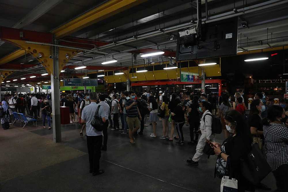 Commuters queueing for free shuttle bus at Jurong East bus interchange in Singapore about 9.35pm on October 14, 2020 after trains broke down. u00e2u20acu201d TODAY pic 