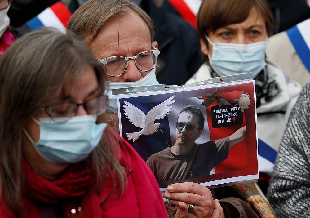 A person holds a picture of Samuel Paty, the French teacher who was beheaded on the streets of the Paris suburb of Conflans St Honorine, during a tribute in Lille, France October 18, 2020. u00e2u20acu201d Reuters pic
