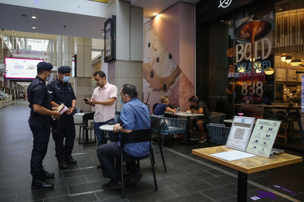 Police personnel check on mall-goers at Pavilion, Kuala Lumpur October 14, 2020. — Picture by Yusof Mat Isa