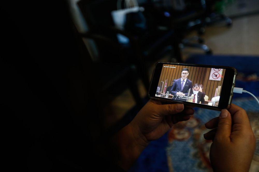 A woman watches a live broadcast of the third term of the 14th Penang State Legislative Assembly session on her phone in George Town October 12, 2020. u00e2u20acu201d Picture by Sayuti Zainudin 