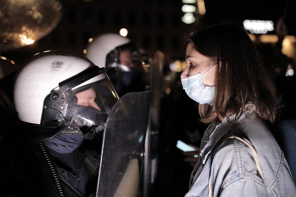 A woman stands in front of police officers during a protest against the ruling by Poland's Constitutional Tribunal that imposes a near-total ban on abortion, in Warsaw, Poland October 26, 2020. u00e2u20acu201d Agencja Gazeta pic via Reuters