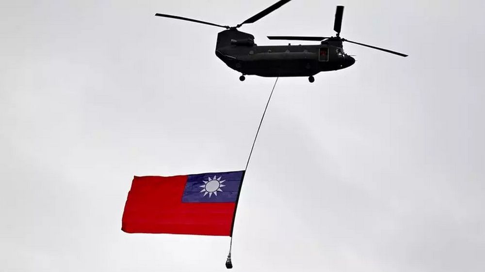 A military helicopter flies a Taiwan flag during a national day parade in Taipei on October 10. Beijing regards Taiwan as its own territory and has vowed to one day seize the self-ruled island. u00e2u20acu201d AFP file pic