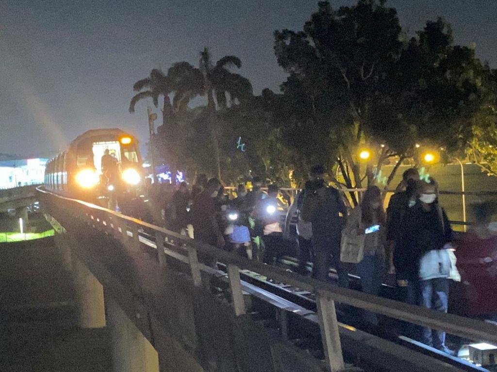 Passengers walk along the track after the emergency doors were opened for them near Jurong East MRT station on Oct 14, 2020. u00e2u20acu201d TODAY pic