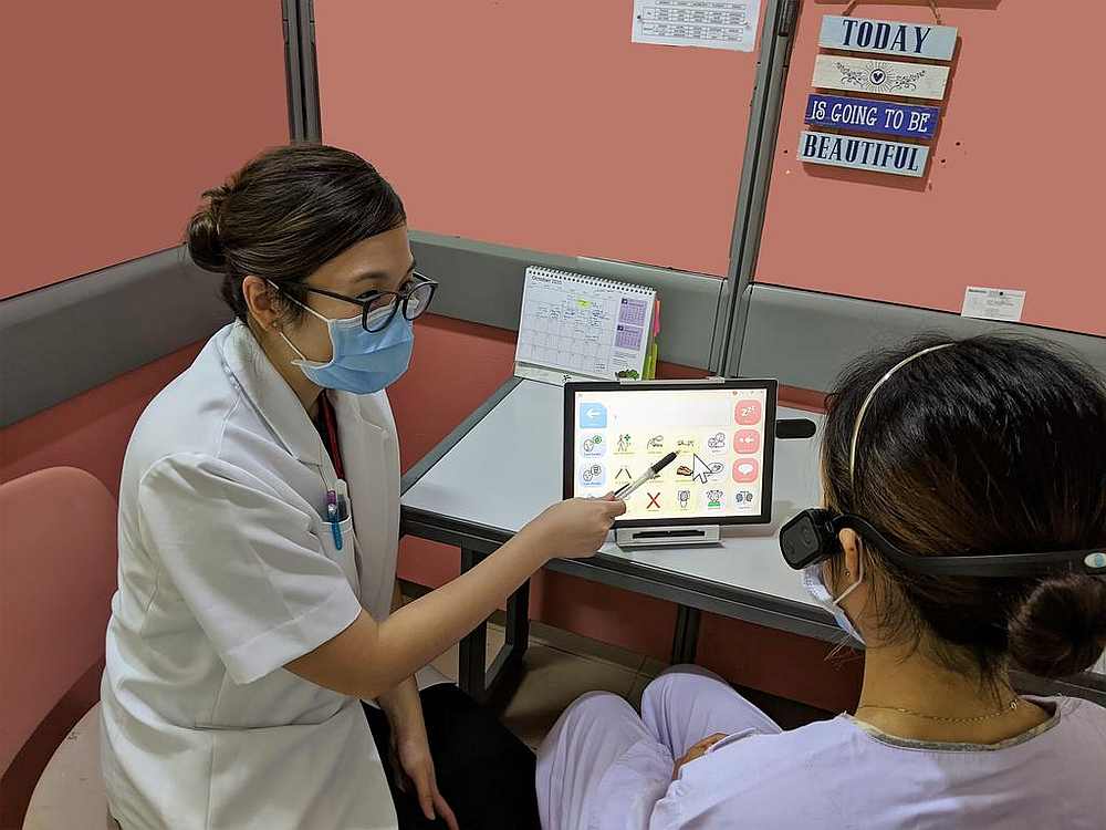 A senior speech therapist at Tan Tock Seng Hospital training a patient to communicate using an eye-gaze tracking sensor. u00e2u20acu201d Picture courtesy of Tan Tock Seng Hospital via TODAY