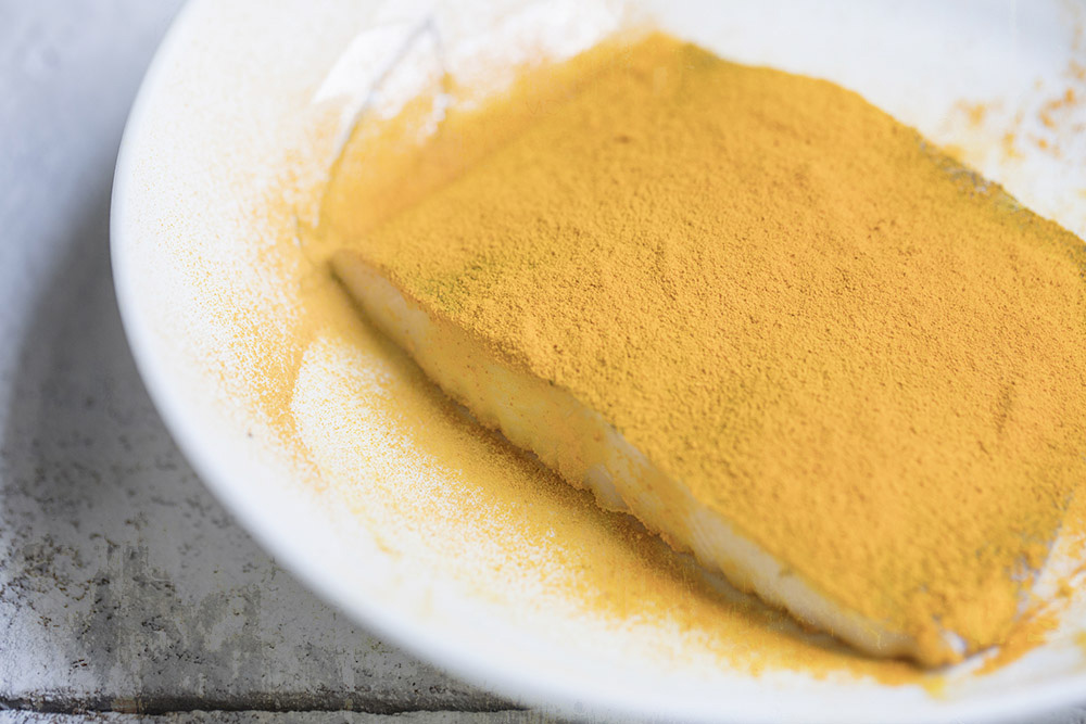 A coat of gold: once the halibut is dusted with turmeric powder.