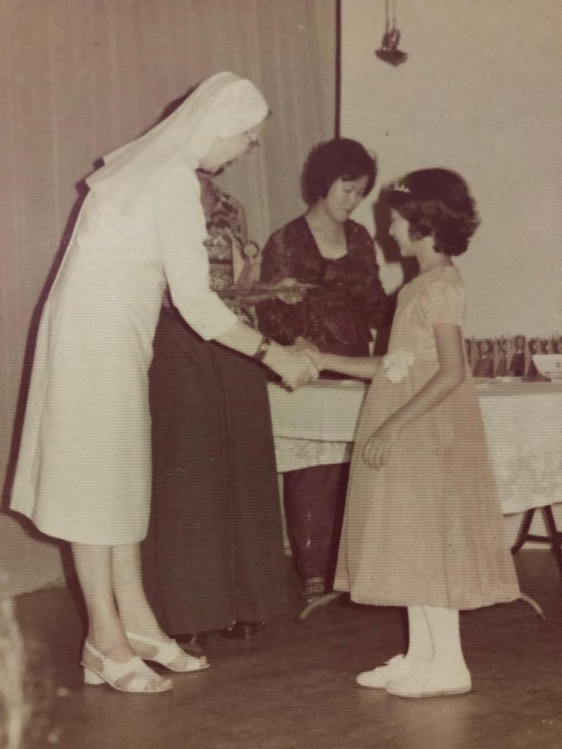 Melinda at age eight receiving a prize from then CLS principal Sister Frances de Sales. — Picture courtesy of Melinda Lim