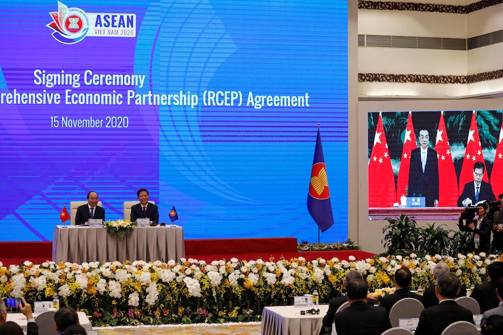 Vietnam's Prime Minister Nguyen Xuan Phuc (left) sits next to Minister of Industry and Trade Tran Tuan Anh during the virtual signing ceremony of the Regional Comprehensive Economic Partnership (RCEP) Agreement in Hanoi, Vietnam November 15, 2020. u00e2u20acu201d Reu
