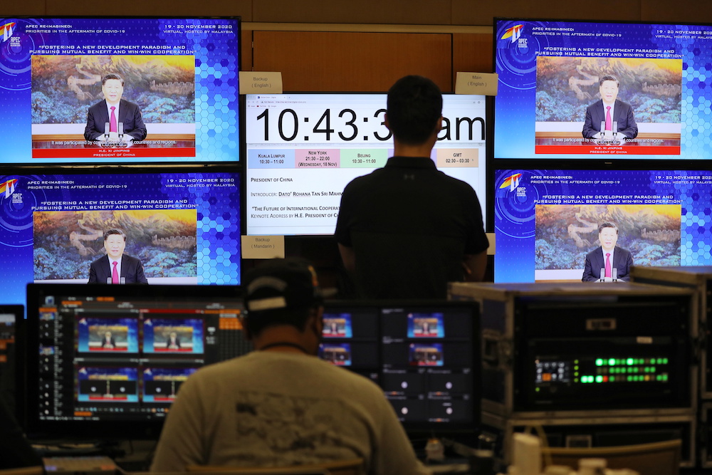 People look at a screen showing Chinau00e2u20acu2122s President Xi Jinping speaking during virtual Apec CEO Dialogues 2020 at command center, in Kuala Lumpur November 18, 2020. u00e2u20acu201d Reutesr pic