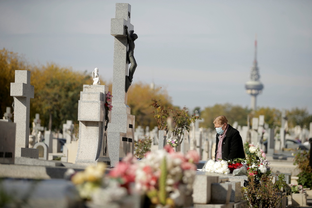 A mourner stands next to tombstones at a cemetery during All Saints Day, amid the coronavirus disease (Covid-19) outbreak, in Madrid, Spain November 1, 2020. u00e2u20acu201d Reuters picn n