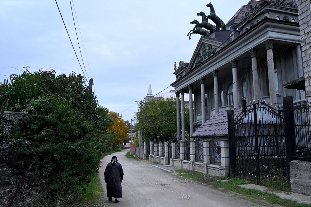 An elderly woman walks past a house, that somewhat resembles Moscow's Bolshoi Theatre, in the Gypsy Hill quarter in the town of Soroca, some 155 km north of Chisinau October 31, 2020. u00e2u20acu201d AFP pic
