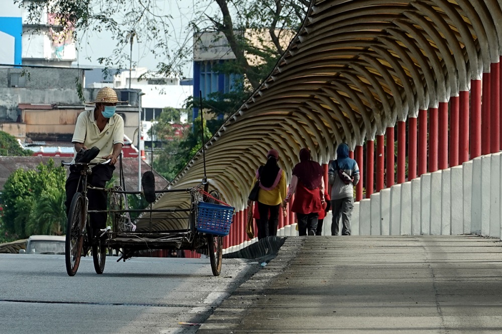 A man paddles his tricycle in Klang November 5, 2020. u00e2u20acu201d Picture by Miera Zulyana