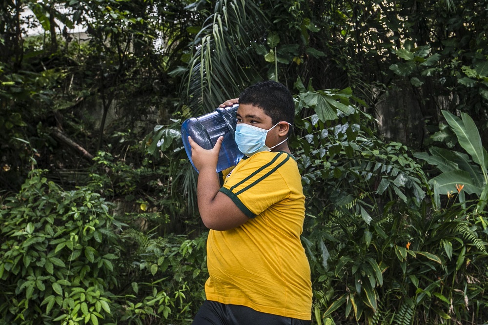 A boy carries a container of water at a water point in Keramat AU2 following the latest water disruption November 11, 2020. u00e2u20acu201d Picture by Firdaus Latif