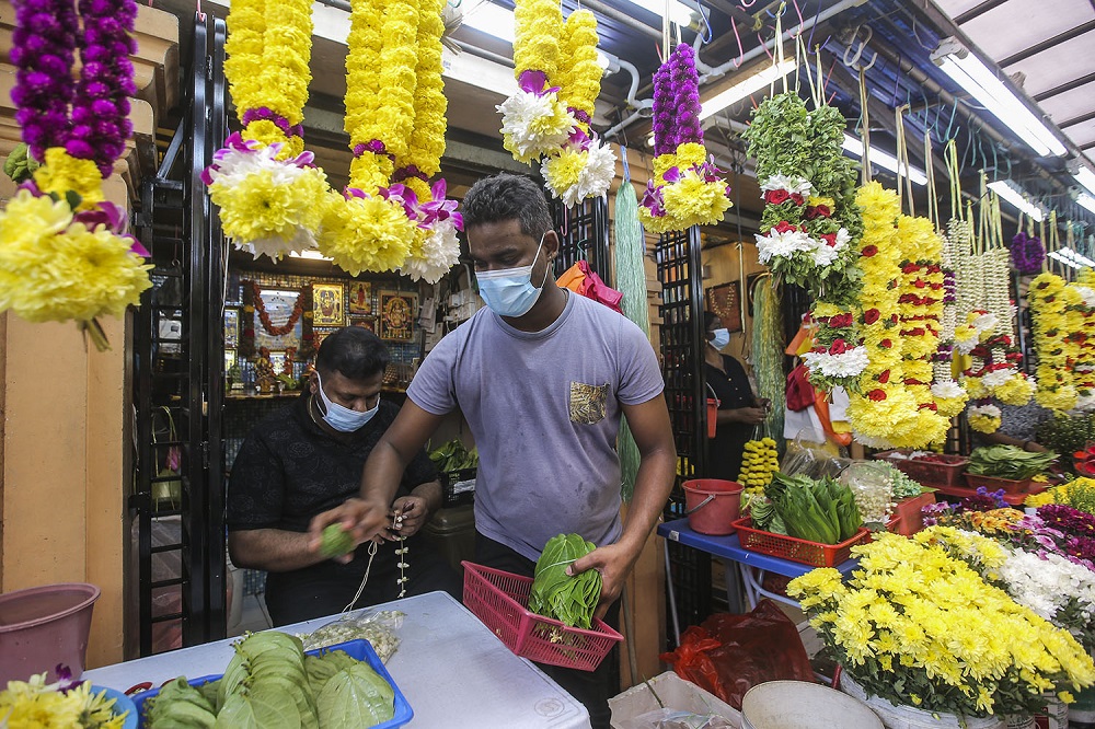 Malai flower traders R. Kuna (right) works at his shop in Brickfields, Kuala Lumpur November 11, 2020. 