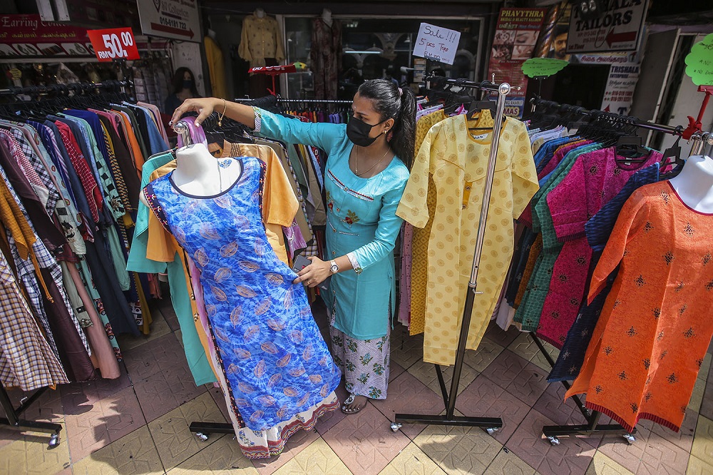 Kogila Prieyaah arranges clothing outside BGV boutique in Brickfields, Kuala Lumpur.