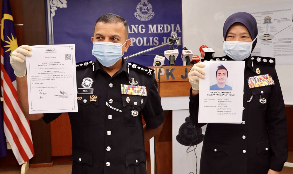 Johor police chief Datuk Ayob Khan Mydin Pitchay (left) holds a document detailing the investigation into the syndicateu00e2u20acu2122s activities. u00e2u20acu201d Picture courtesy of the Johor police contingent headquarters