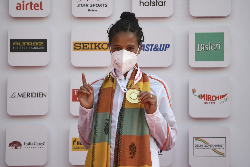 First placed Ethiopian athlete Yalemzerf Yehualaw celebrates with her gold medal at the podium during the medal ceremony of the women's 2020 Airtel Delhi half marathon in New Delhi on November 29, 2020. — AFP pic