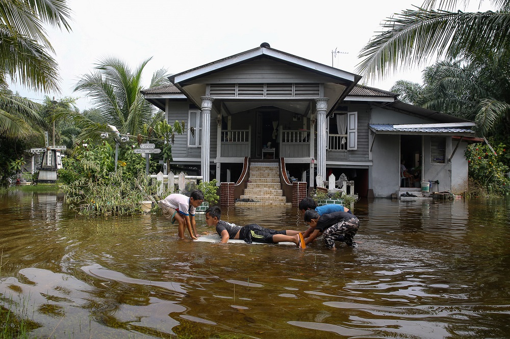 Children play in floodwater in front of their house in Kampung Bukit Hijau Jeram in Kuala Selangor November 30, 2020. u00e2u20acu201d Picture by Yusof Mat Isa